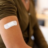 Article thumbnail: Bandage on arm of a female after taking vaccine. Close-up of a female patient with bandage on hand after taking injection.